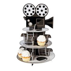 a three tiered cupcake stand with film reels and cupcakes on it