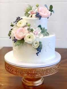 a three tiered white wedding cake with pink and white flowers