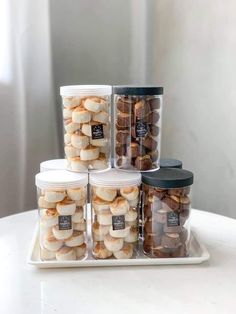 several containers filled with food sitting on top of a white table next to each other