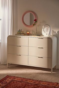 a white dresser with a mirror and vase on top