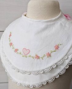 Beautiful baby bib...designed in a double layer.  The top layer is lined with soft white flannel and the under bib is lined with soft terry cloth.  Both layers are edged with pretty lace edging. Pretty hand embroidery makes this bib extra special.  It's perfect for baby's christening or 1st birthday! Bib ties with pretty pink gingham ribbon. Fits babies and toddlers Bib Embroidery, Cute White Bib For First Birthday, Cute Cotton Bib As Gift, Cute White Bib Front Bib, Cute Pink Bib As A Gift, Cute Pink Bib As Gift, Embroidered Bibs, Cute Handmade White Bib, Pink Cotton Bib As A Gift