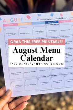 a hand holding up a calendar with the text grab this free printable august menu calendar