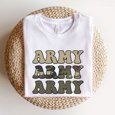 "\"Army\" Shirt. This soft camo tee makes a great gift for any soldier, army wife or army mom! This classic unisex jersey short sleeve tee fits like a well-loved favorite. Soft cotton and quality print make users fall in love with it over and over again. These t-shirts have-ribbed knit collars to bolster shaping. The shoulders have taping for better fit over time. Dual side seams hold the garment's shape for longer. - 100% Airlume combed and ringspun cotton (fiber content may vary for different Camouflage Cotton T-shirt With Letter Print, Camouflage Graphic Tee With Print, Camouflage Cotton Top With Letter Print, Camouflage Crew Neck T-shirt With Letter Print, Deployment Homecoming, Army Mom Shirts, Army Shirt, Camo Tee, Army Mom