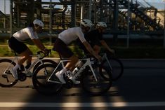 two bicyclists are riding down the street together