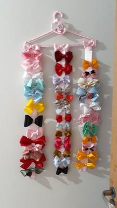 several different colored bows hanging on a wall