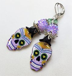 Fun and Sparkly Halloween earrings! Super lightweight. Handmade image with resin Skull charms by Canadian artist Susan. I added lavender crystal sparkle beads. These earrings are three inches long. One Of A Kind I can send it gift wrapped (free of charge), if requested and will be ready for giving Want to come see some of my other gorgeous earrings and necklaces? https://etsy.me/2Go6Uxf Multicolor Halloween Earrings For Gift, Multicolor Halloween Earrings Gift, Handmade Skull Earrings For Day Of The Dead, Halloween Skull Print Earrings, Halloween Resin Jewelry Gift, Handmade Resin Jewelry For Halloween, Halloween Gift Resin Jewelry, Handmade Earrings For Day Of The Dead, Whimsical Halloween Dangle Jewelry