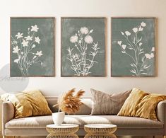 a living room with two couches and paintings on the wall above them in black and white