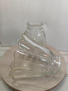 a glass vase sitting on top of a wooden stand