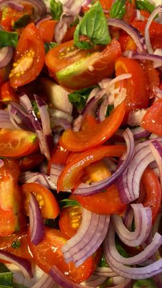 a salad with tomatoes, onions and lettuce is shown in close up view