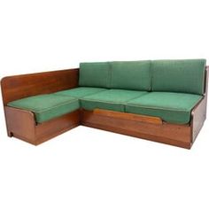 a green couch sitting on top of a wooden floor