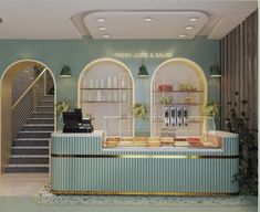 the interior of a restaurant with green walls and white trim on the counter, along with stairs leading up to the second floor