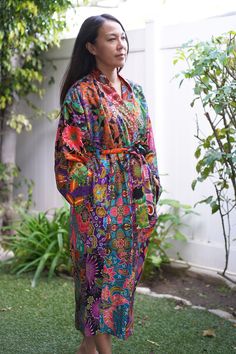 This is a long washable printed batik robe/ kimono handmade by artisans, thick duster and home jacket. Eco-friendly, upcycled fabric for conscious fashion. The fabric was sourced from surroundings clothing manufacturer that would have been otherwise discarded. Because of the upcycled material and handmade nature of this item, each batik quilt kimono is not alike. The print will be of slightly different pattern and color but in variation of black, blue, pink, purple, green mix pattern. This thick Cotton Kimono With Batik Print And Long Sleeves, Multicolor Cotton Robe With Floral Print, Bohemian Cotton Kimono With Batik Print, Multicolor Batik Print Kimono For Spring, Spring Multicolor Kimono With Batik Print, Long Multicolor Cotton Robe, Multicolor Cotton Robe For Festival, Multicolor Long Cotton Robe, Bohemian Batik Print Patterned Kimono