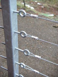 a close up of a metal fence with many links attached to the top and bottom