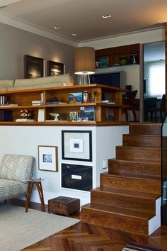 a living room filled with lots of furniture and bookshelves next to a stair case