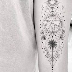 a person with a tattoo on their arm that has a compass and palm tree in it