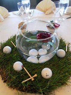 an arrangement of golf balls and tees in a bowl on top of some grass