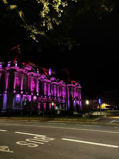 an old building is lit up with purple lights