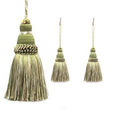 three tassels are hanging from strings on a white background and one is green