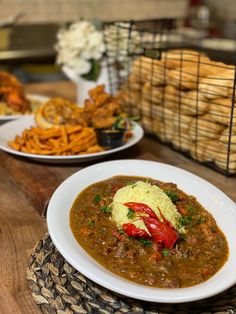 two plates of food are sitting on a table with other dishes in front of them