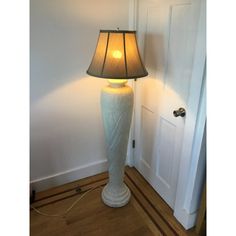 a lamp that is on top of a table next to a door with a light on it