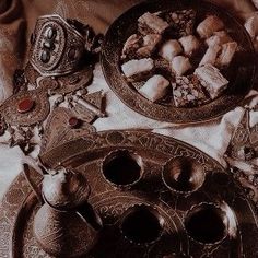 an assortment of silver items on a table with cloths and napkins in the background