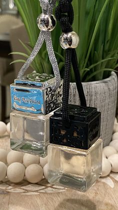 three small square glass containers sitting on top of a table next to a potted plant