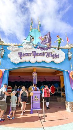 the entrance to peter pan's flight at disneyland world with people standing in front