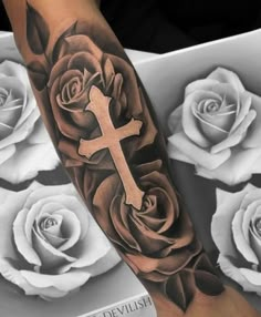 a rose with a cross tattoo on the arm