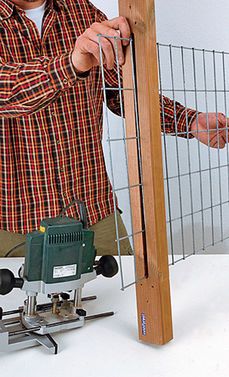 a man is working on a piece of wood that has been placed in a fence