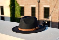 A new spin on our best-selling hat, the Clarke fedora embodies a balance between modern and vintage with its simplistic design, which is offset by a hand-stitched leather headband. Available in size Medium 54-58cm and Large 59-62cm. Features an adjustable inner strap to ensure your hat is the proper fit. Removable headband Specifications:Crown Height: 5"Brim Width for Medium: 2.65"Brim Width for Large: 2.9"Material: Polyester All hats ship from Dallas, Texas. Adjustable Fedora For Everyday Wear In Fall, Adjustable Fedora For Everyday Fall Wear, Adjustable Fedora For Everyday Use In Fall, Black Fedora With Flat Crown For Spring, Adjustable Flat Crown Fedora For Fall, Black Fedora With Flat Crown For Fall, Adjustable Black Flat Brim Fedora, Adjustable Casual Felt Hat With Flat Crown, Black Fedora With Curved Brim For Everyday