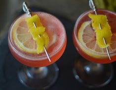 two glasses filled with orange juice and garnished with lemon