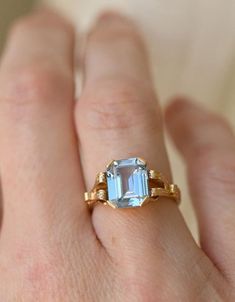 a woman's hand with a ring that has an aqua blue stone on it