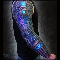 a man's arm with a blue and purple tattoo design on the left arm