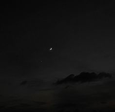 the moon and venus are visible in the dark night sky above some clouds on a cloudy day