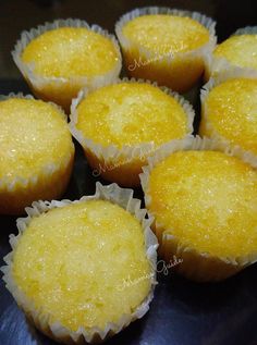 some yellow cupcakes are sitting on a black plate and ready to be eaten