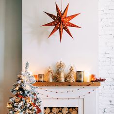 a christmas tree is next to a fire place with decorations on it and a star above the fireplace