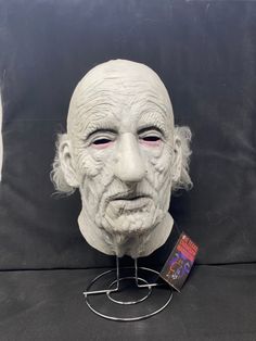 an old man's head is shown on a stand