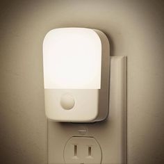 a light that is on the side of a wall next to a plugged outlet