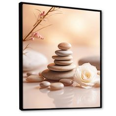 a white rose and some rocks on a table