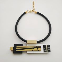 "A unique black white and gold statement necklace. This necklace will star with a classic black dress on any occasion. Definitely a necklace for a stylish modern women! Lightweight necklace. * * * * * * * * * * * Length: 18\"/46c\"m + 3\"/7.5c\"m extender. Maximum length: 21\"/53.5c\"m Need a different length? message me about it. Central element measurements: width: 5.7\"/14.5c\"m height: 1.8\"/4.5c\"m maximum thickness: 0.6\"/15 m\"m Materials: 0.31\"/8 m\"m thick black silicon cord 0.12\"/3m\ Modern Black Necklace For Evening, Bold Black Necklace For Gifts, Bold Black Necklace For Gift, Unique Black Geometric Jewelry, Modern Black Geometric Necklace, Geometric Black Necklace For Gift, Black Geometric Necklace For Gift, Black And Gold Necklace, Black White And Gold