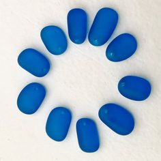 blue glass pieces arranged in a circle on a white surface