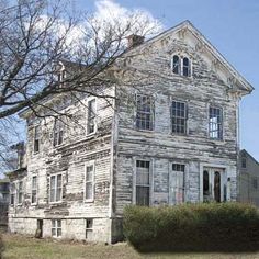 an old house sitting in the middle of a field