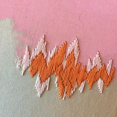 an orange and white piece of fabric with some stitching on the side of it