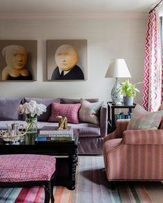 a living room filled with furniture and paintings on the wall