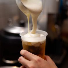 a person is pouring liquid into a cup