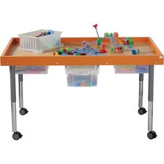 an orange table with plastic bins and toys on it