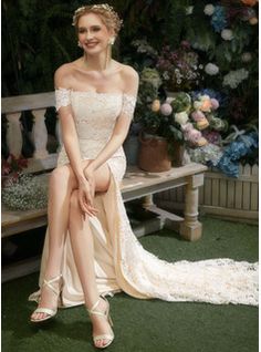 a woman sitting on top of a bench in front of some flowers and greenery