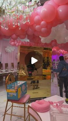 a room filled with lots of pink balloons