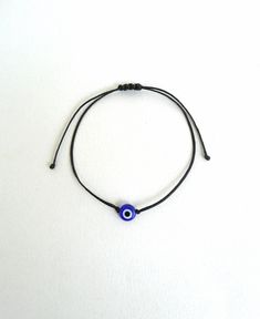 The evil eye is used to protect the person that wears it from the malevolent look of others who envy or dislike that person. This macrame bracelet is made out of black waxed string. 8mm flat eye glass bead At the end it is adorned with blue glass seed beads. It is adjustable to fit a lot of sizes. Other evil eye bracelets in my shop: https://www.etsy.com/shop/LuckyRatJewellery?section_id=14785936&ref=shopsection_leftnav_5 *Colours may differ slightly from the original due to the configuratio Evil Eye Bracelet Png, Affordable Black Beaded Evil Eye Bracelet, Cheap Black Evil Eye Bracelet, Bracelets Eye Evil, Minimalist Adjustable Beaded Bracelets With Evil Eye, Minimalist Adjustable Evil Eye Bracelet As Gift, Minimalist Adjustable Evil Eye Bracelet, Minimalist Adjustable Evil Eye Bracelet For Everyday, Minimalist Evil Eye Beaded Bracelets As Gift