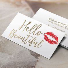 two business cards with the words hello beautiful written in gold ink on them, sitting on a marble surface